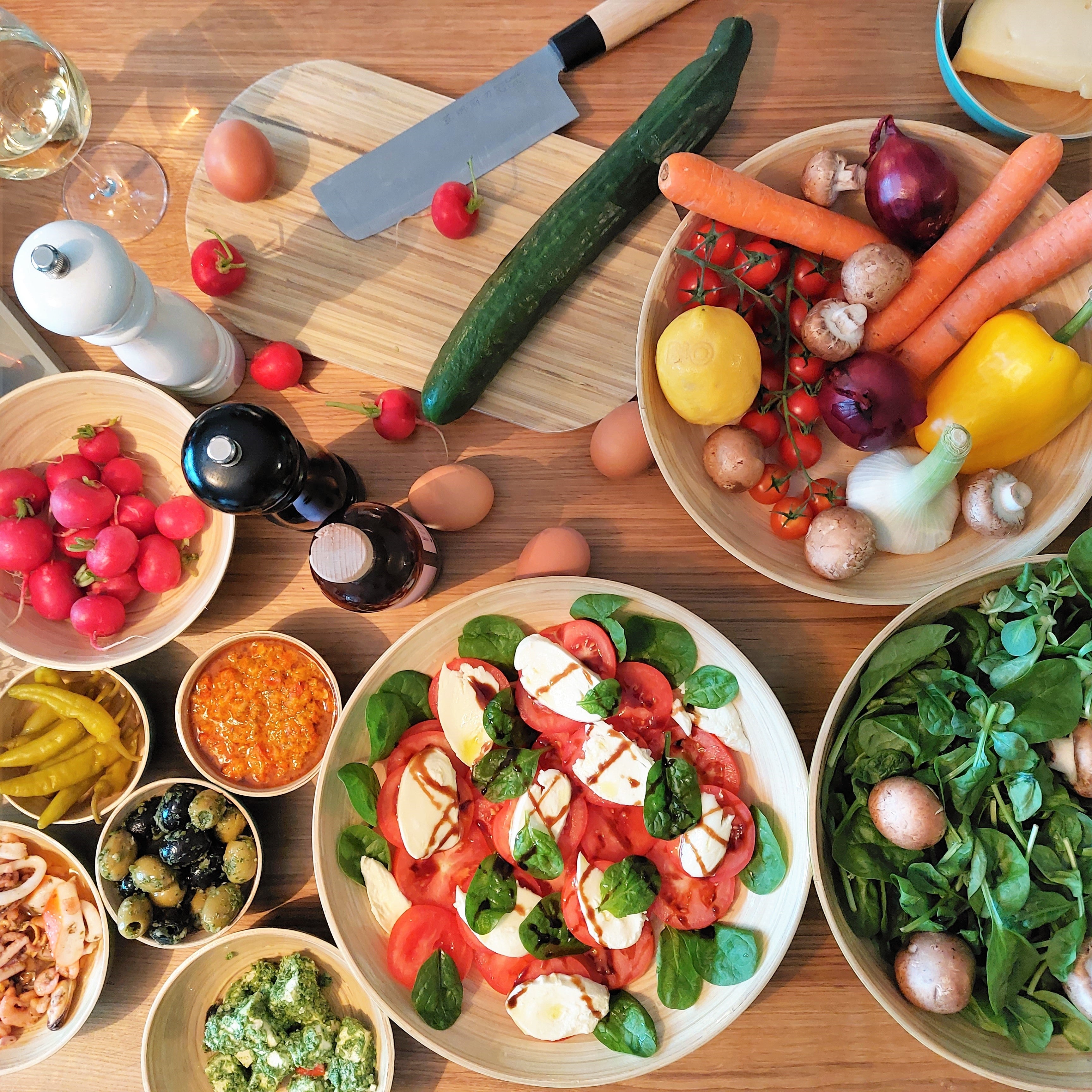 Eingedeckter Tisch mit einer Vielzahl an albert L. (punkt) Bambus-Schüsseln die mit Salat gefüllt sind